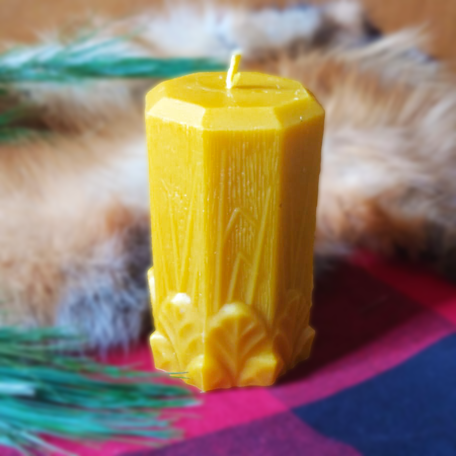 Octagonal pure beeswax candle with garden leaves and grasses at the bottom
