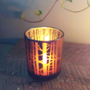 one tealight burning in forest candle holder